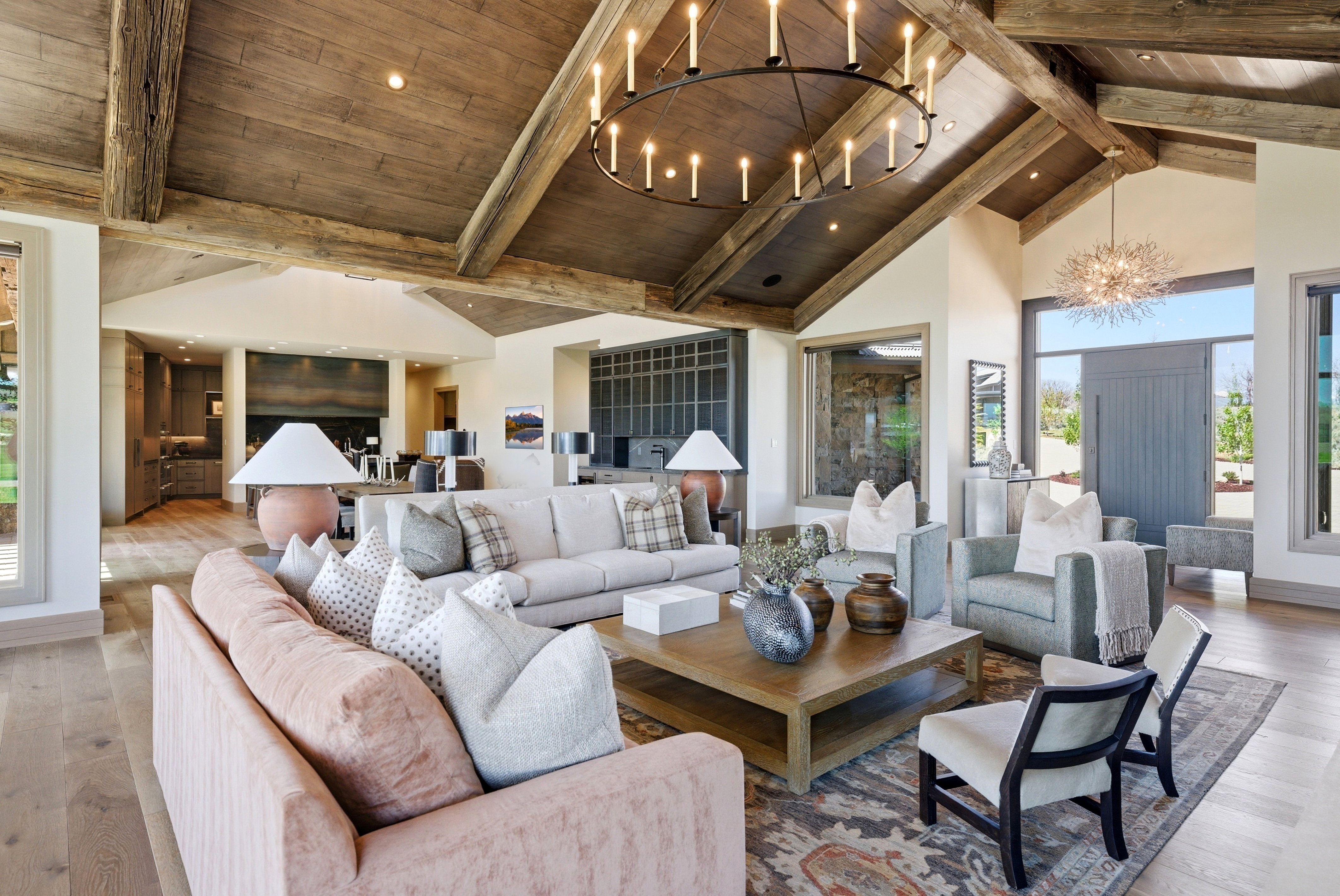Living area featuring a vaulted wood-beam ceiling with wood-finish planks, a large circular chandelier, and light wood-finish flooring