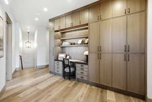 Built-in desk area with integrated shelving and task lighting, complemented by extensive full-height cabinetry