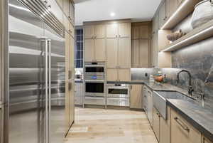 Gourmet kitchen featuring a stainless steel refrigerator, integrated double ovens, and a built-in microwave