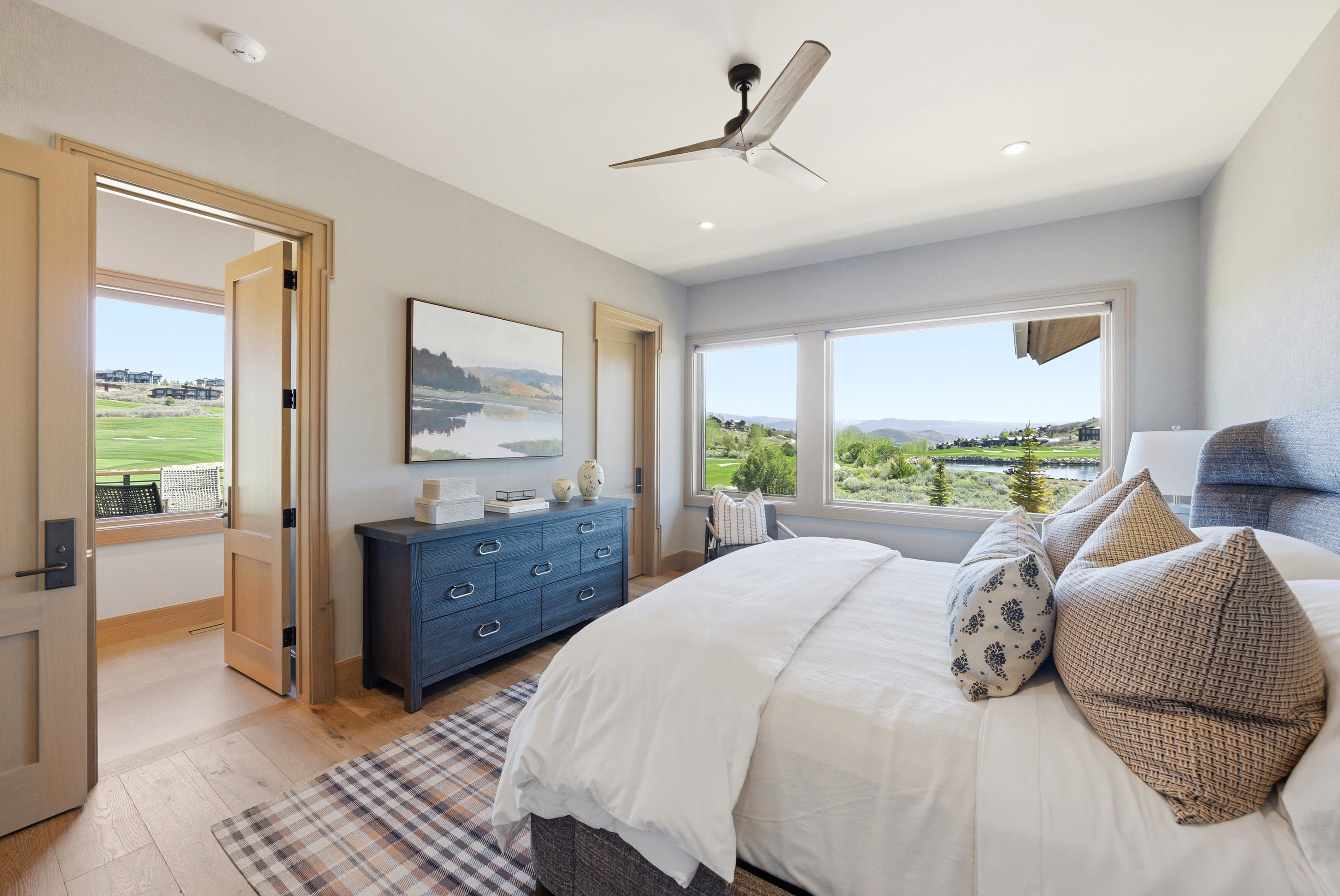 Bedroom featuring expansive windows, wood-finish flooring, a contemporary ceiling fan, recessed lighting, and a solid core door
