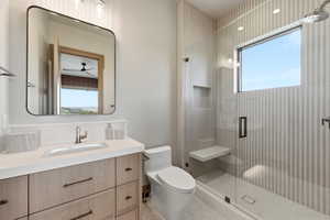 Bathroom featuring a wood-finish vanity with an integrated sink and brushed nickel faucet, a frameless shower with a built-in bench and recessed niche, vertically textured shower wall tiling, and a rectangular window within the shower enclosure
