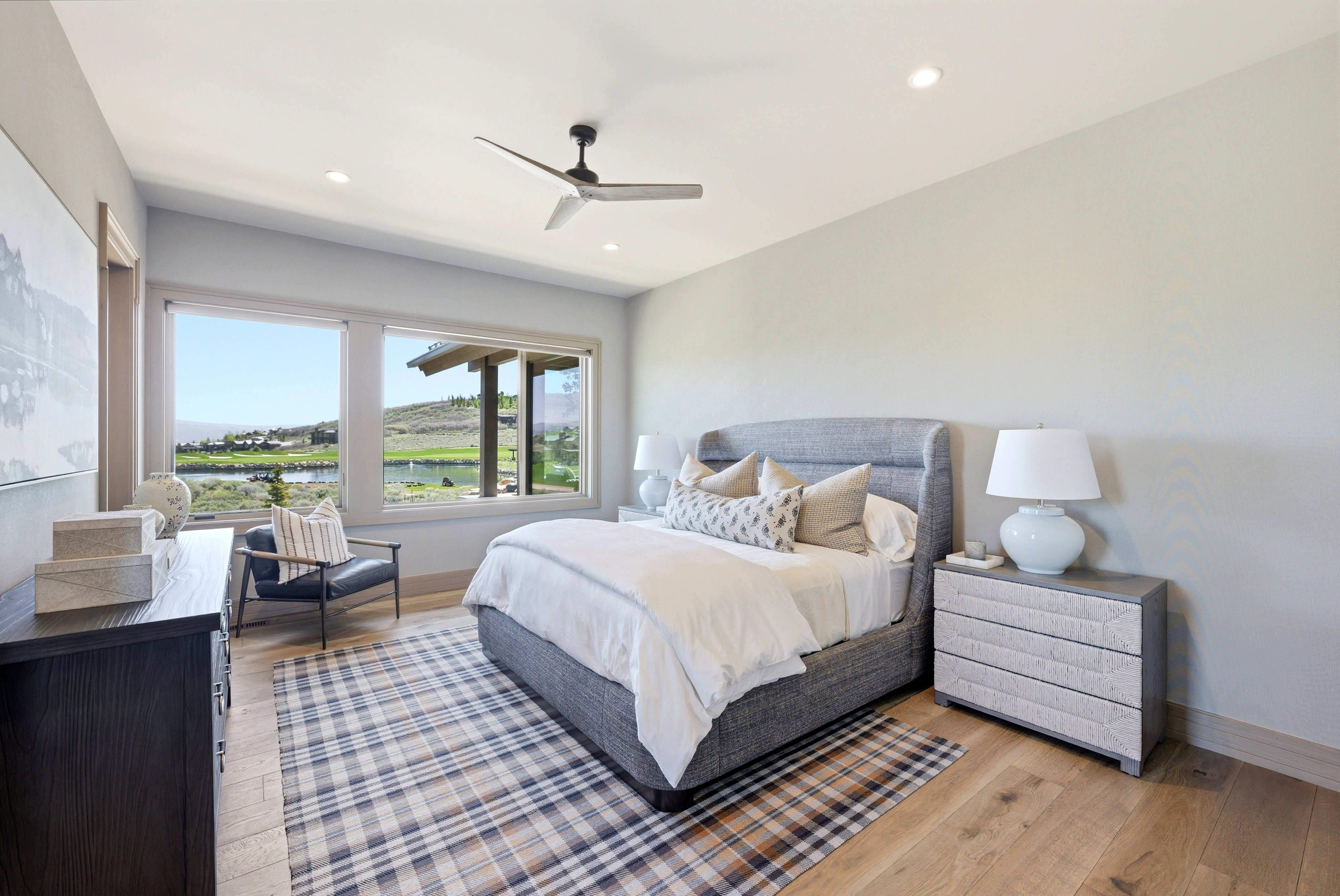 Expansive windows frame the outdoor scenery, complementing the light wood-finish flooring