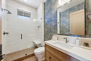 Bathroom featuring a glass-enclosed shower with white subway tile, a built-in shower bench, and a rectangular window
