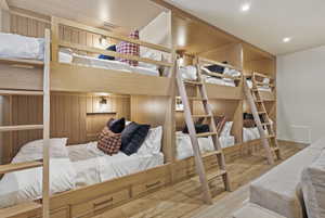 Custom built-in bunk beds featuring wood-finish construction, individual lighting fixtures, integrated storage drawers, and durable ladders