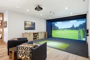 Dedicated golf simulator with a wide screen and putting green