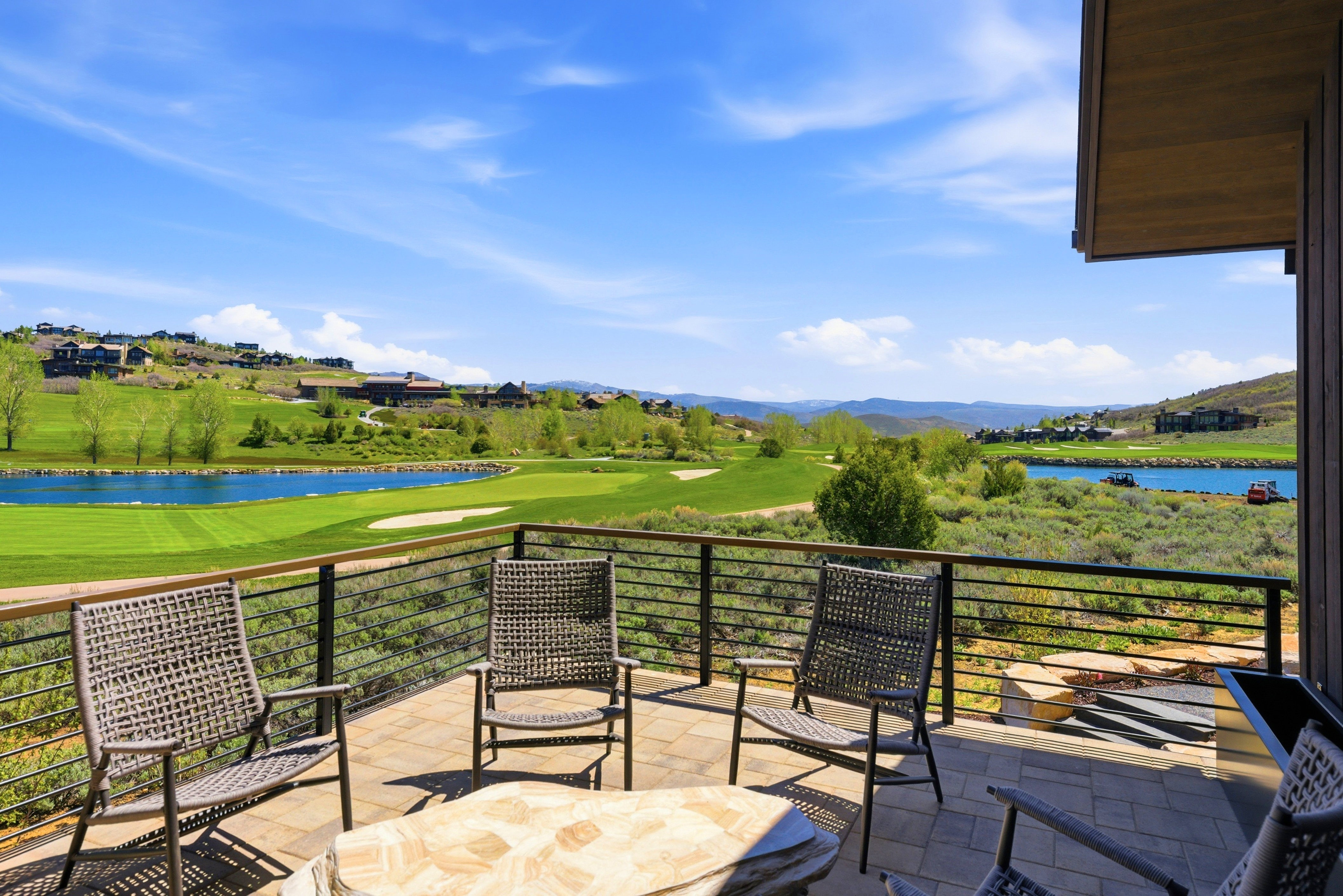 Spacious outdoor patio with tiled flooring and a contemporary metal railing