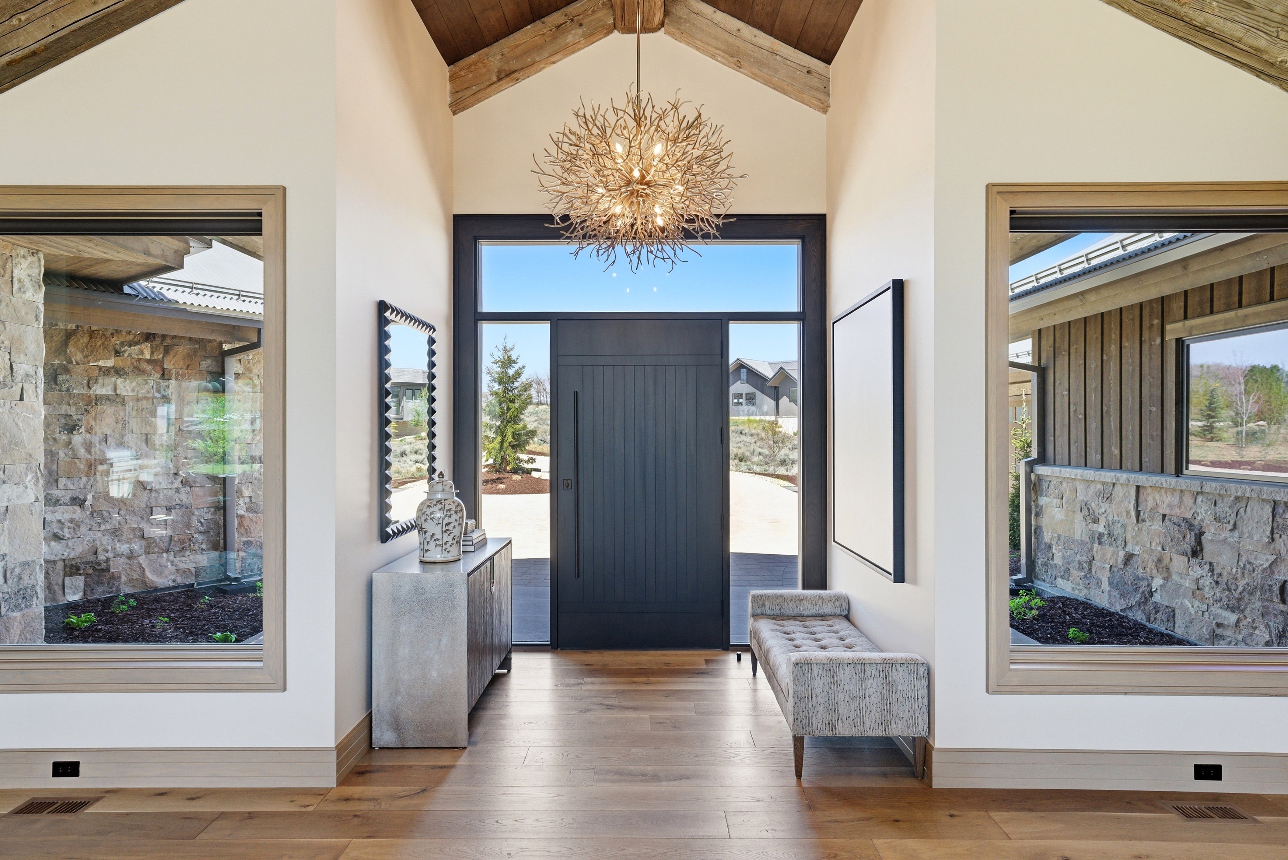 Grand entry featuring a vaulted wood-beam ceiling and a large decorative chandelier