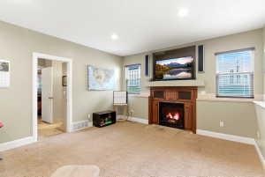 Built-in media center featuring a fireplace with a wood surround and hearth