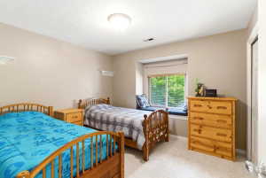 Bedroom featuring a window seat with cushions, neutral carpet, and a flush-mount ceiling light