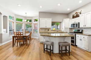Well-appointed kitchen featuring white cabinetry, granite countertops, and stainless steel appliances