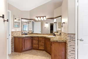 Dual vanity with integrated sinks, speckled countertops, and wood-finish cabinetry