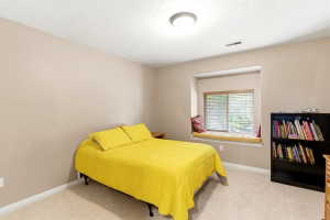 Carpeted room with a recessed window seat, neutral wall color, and a flush mount ceiling light