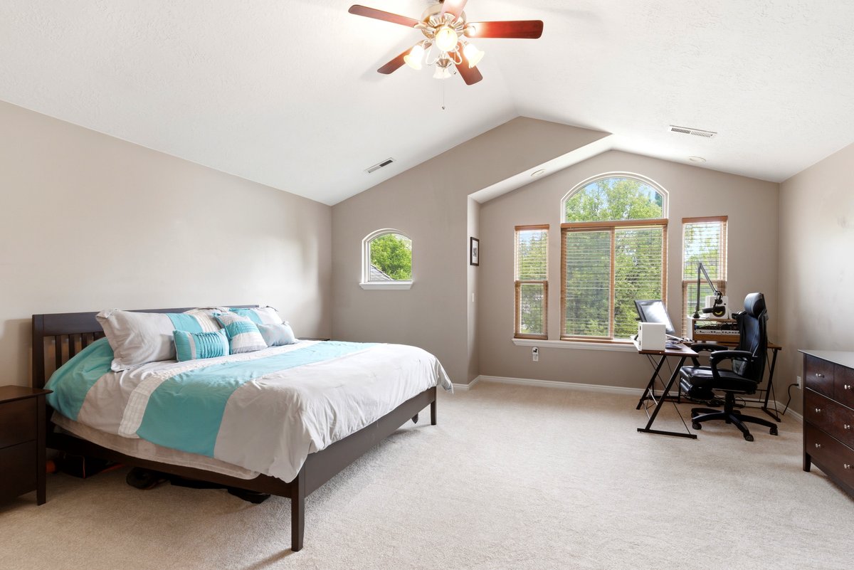 Spacious room featuring vaulted ceilings, a large arched window with two flanking windows, a round-top window, and light-toned carpeting