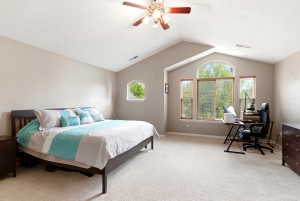 Spacious room featuring vaulted ceilings, a large arched window with two flanking windows, a round-top window, and light-toned carpeting