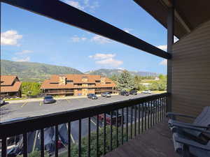 Private balcony featuring wood-finish decking and dark railings