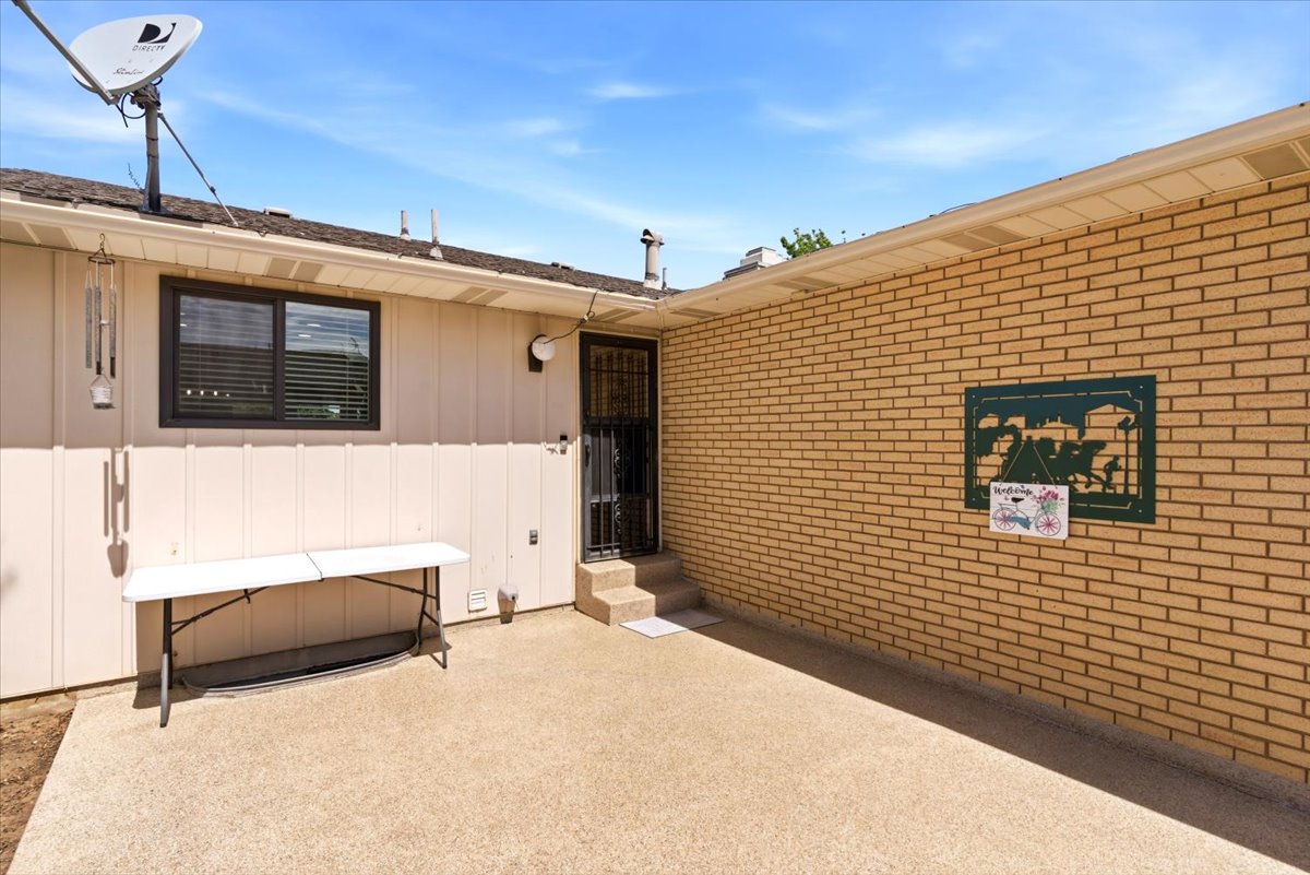 Concrete patio with a brick exterior wall and a siding exterior wall