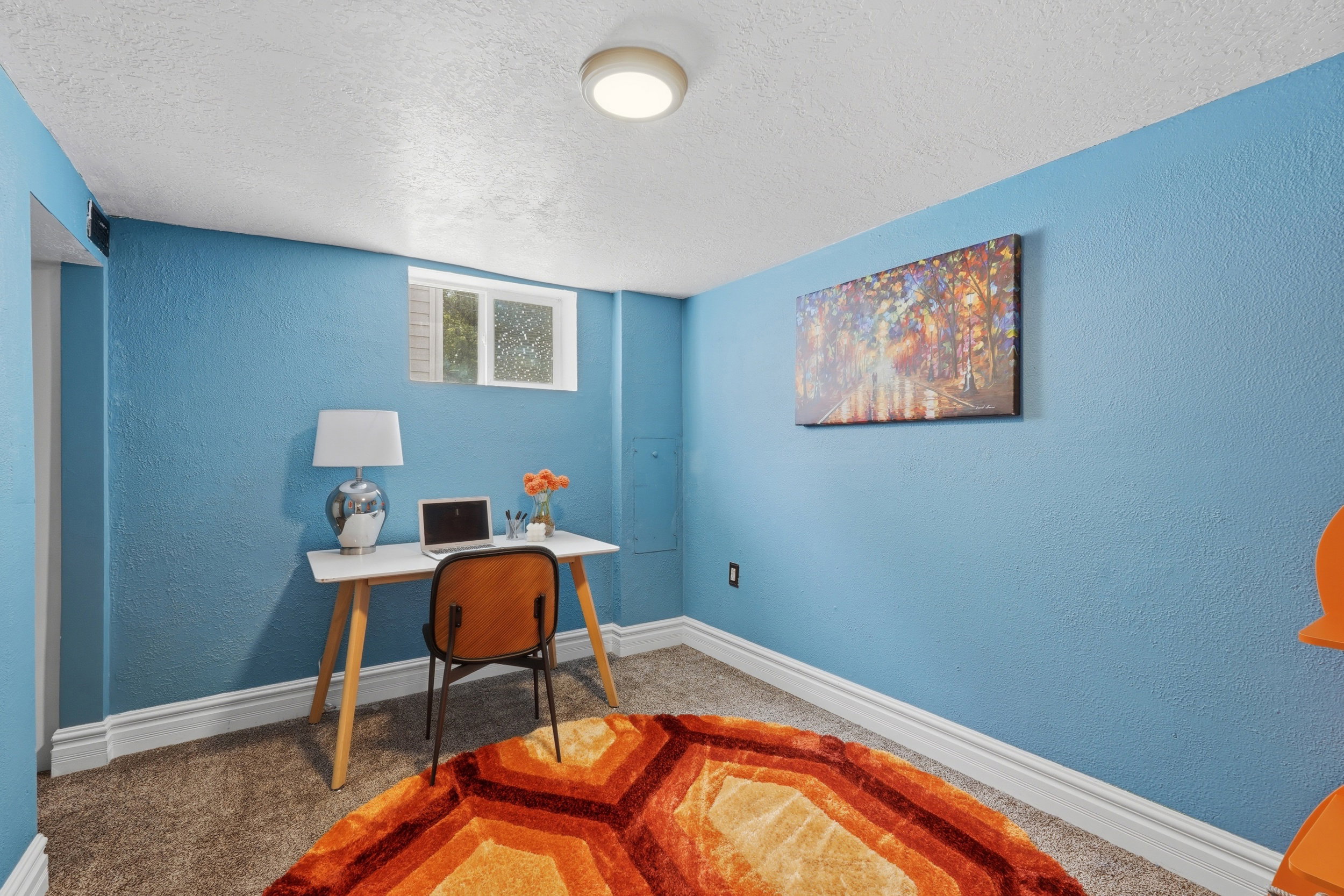 Room featuring blue textured walls, white trim, and a window with frosted glass