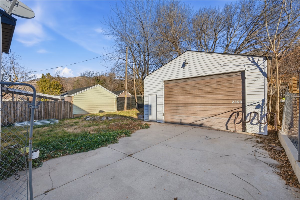 Detached oversized garage with a side entry door, and a roll-up vehicle door. Perfect for wrenching on new projects, cars, or motorcycles.