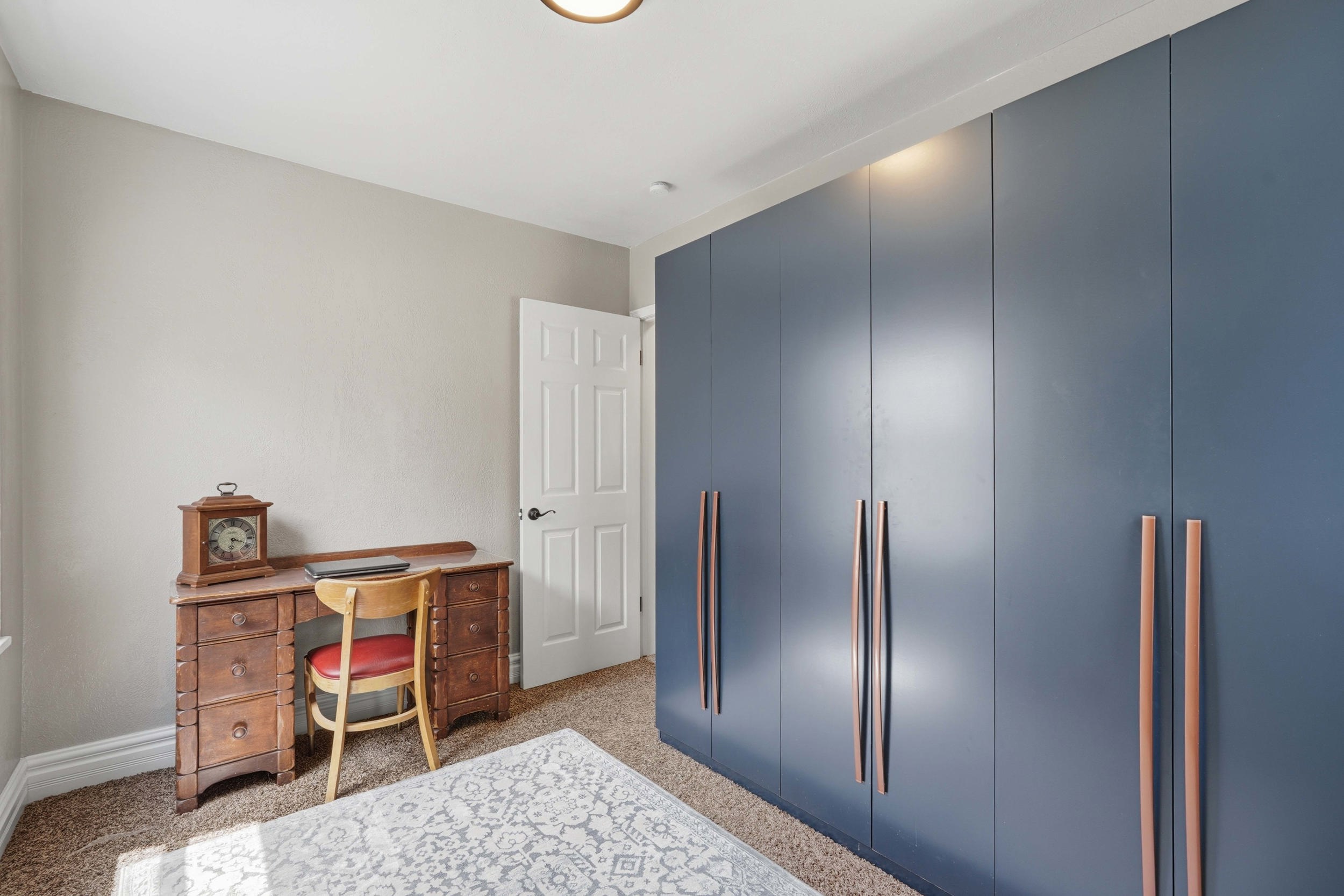 Bedroom 2,  Full-height built-in cabinetry (included) with modern hardware in a neutral-toned room featuring textured carpeting