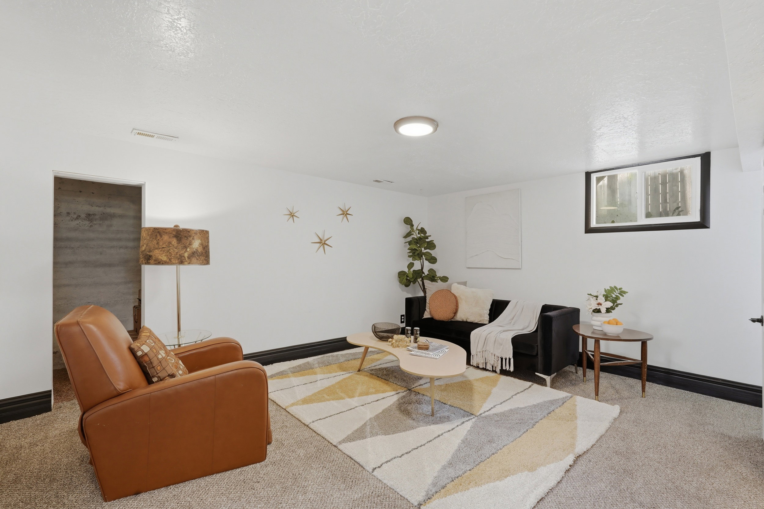 Carpeted living room featuring a ceiling-mounted light fixture, a window with an interior trim, and a doorway