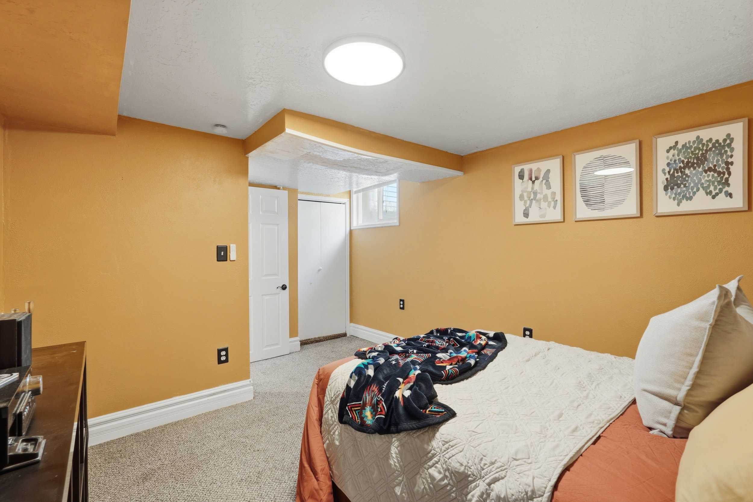 Bedroom 3 Carpeted room featuring a white ceiling, a white door, a white closet with bifold doors, and a small rectangular window