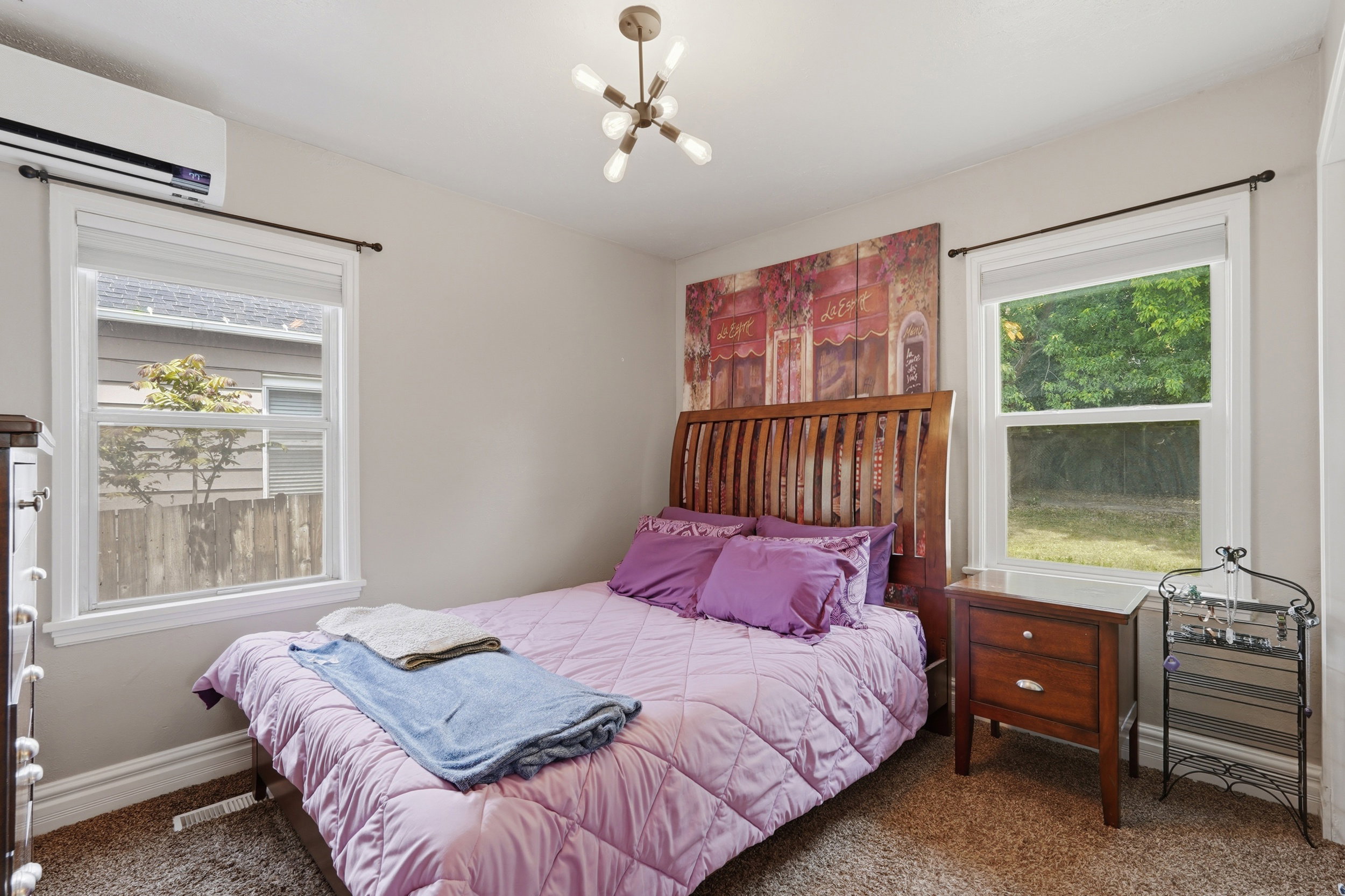 Bedroom 1 featuring two windows, a ceiling-mounted light fixture, and carpet flooring