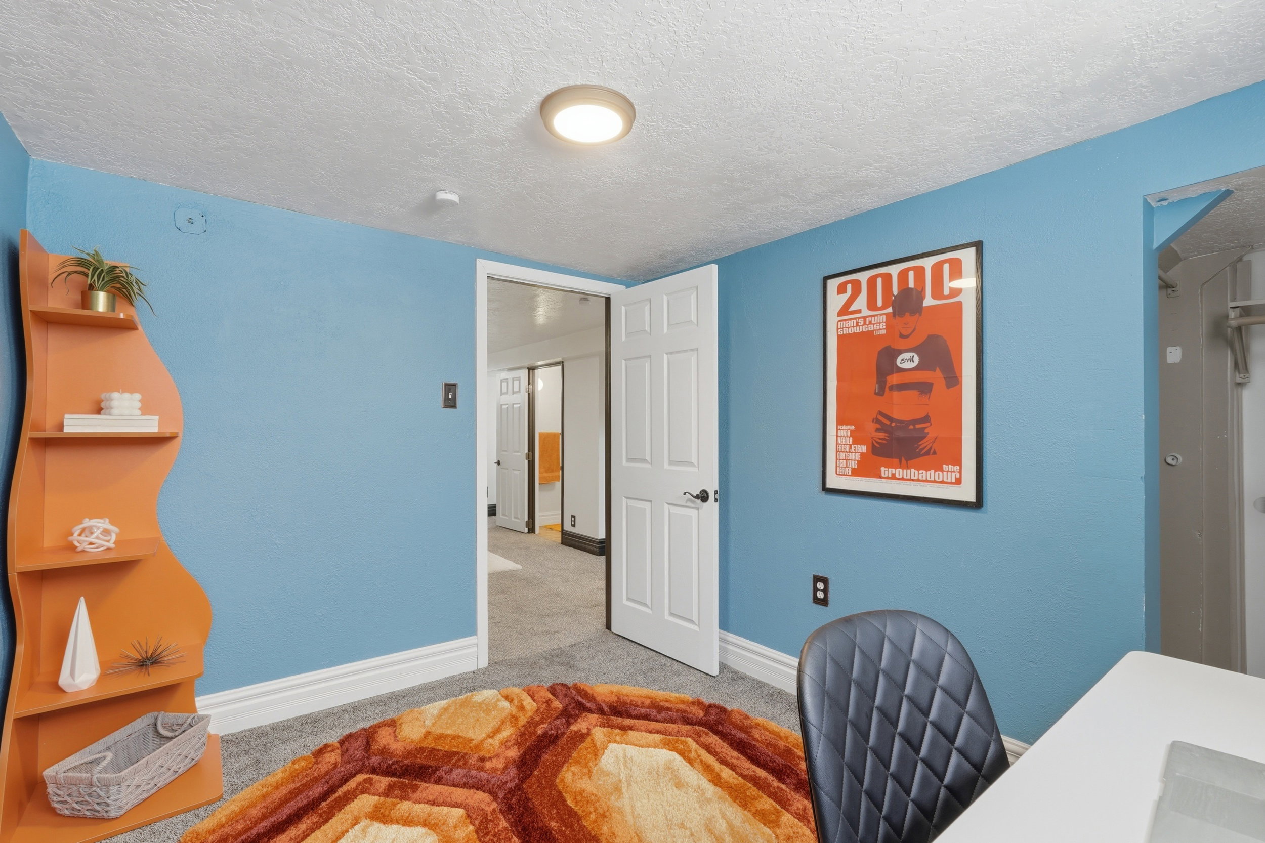 Room featuring textured blue walls, white trim, and a textured ceiling