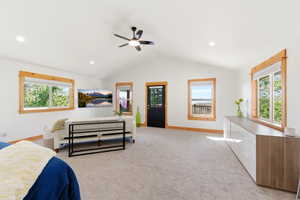 Spacious interior room featuring a vaulted ceiling with a ceiling fan