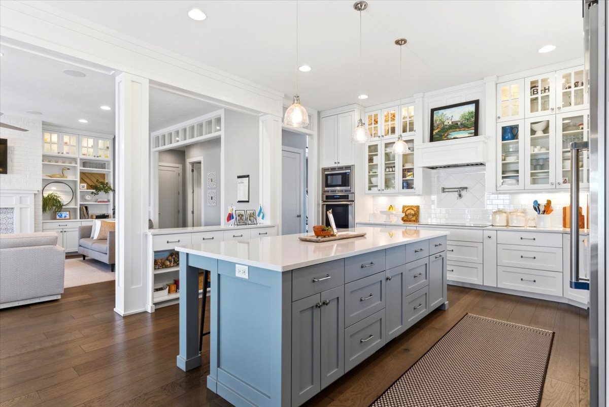 Spacious kitchen featuring a large central island with light blue and gray cabinetry, light countertops, and pendant lighting