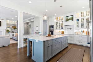 Spacious kitchen featuring a large central island with light blue and gray cabinetry, light countertops, and pendant lighting