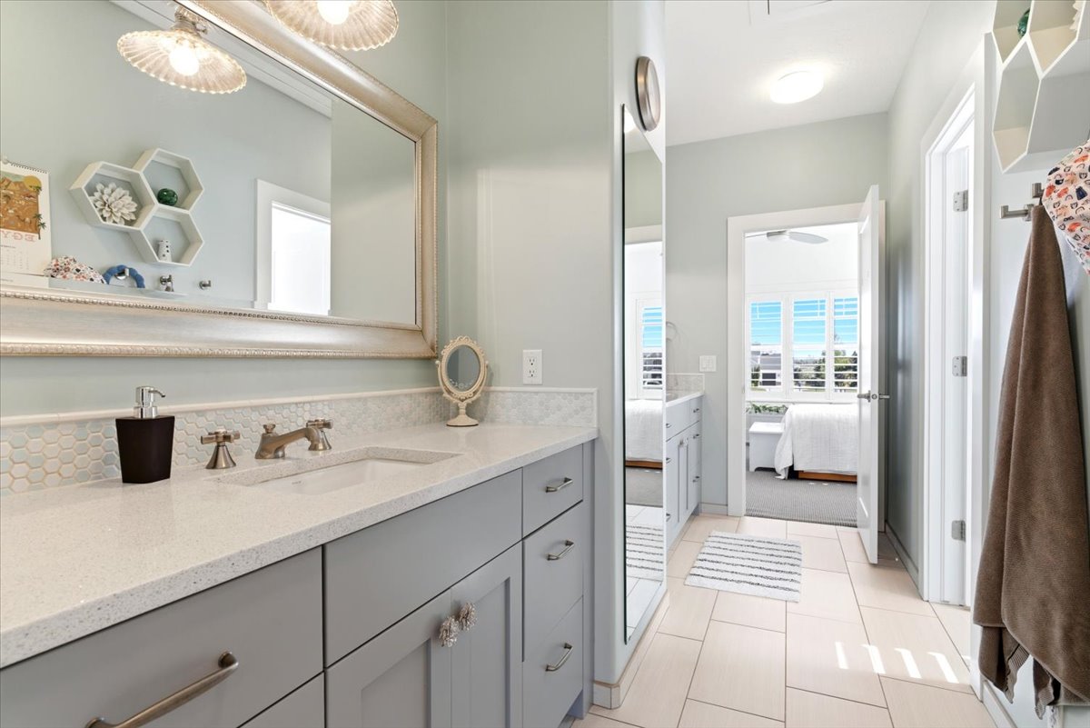 Vanity featuring an integrated sink, light-toned countertop, and a tiled backsplash