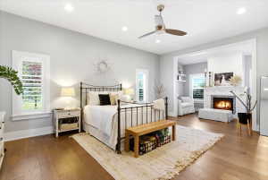 Hardwood flooring throughout featuring a ceiling fan, recessed lighting, and white plantation shutters on windows