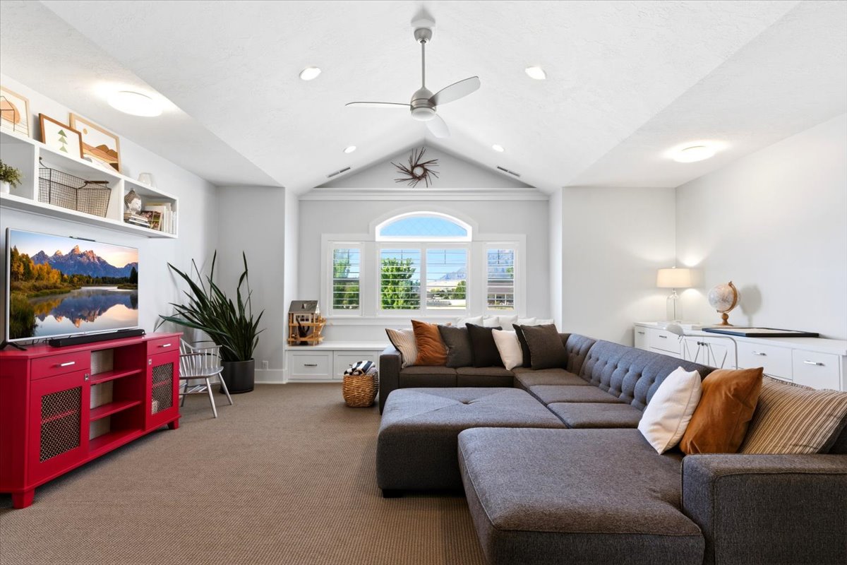 Vaulted ceiling with recessed lighting and a ceiling fan