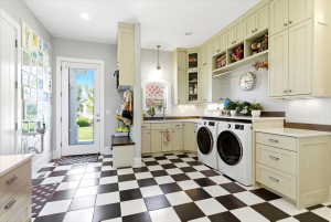 Utility room featuring checkerboard tile flooring, extensive cabinetry, a built-in bench with storage, a countertop workspace, and a glass-paneled exterior door