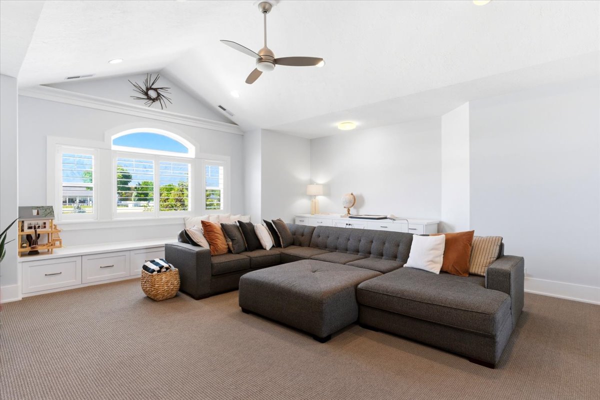 Vaulted ceiling with an overhead fan and recessed lighting