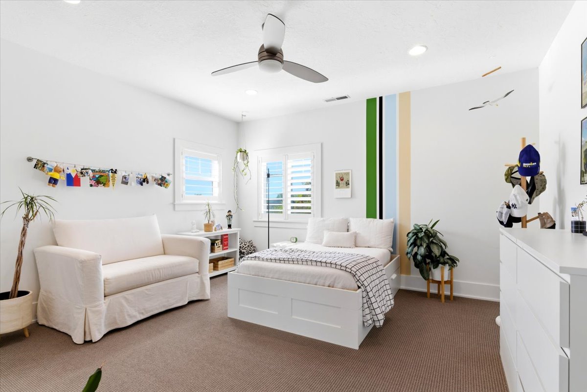 Bright interior space featuring white walls and a ceiling fan with integrated lighting