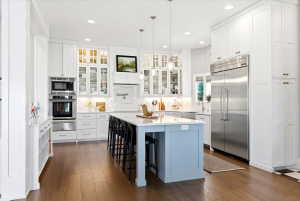 Spacious kitchen featuring wood-finish flooring and extensive white cabinetry