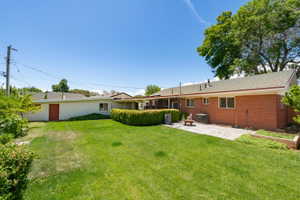 Expansive lawn area featuring a paved patio and brick exterior