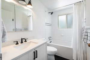 3/4 Bathroom featuring a white vanity with integrated sink, matte black faucet, and coordinating cabinet hardware