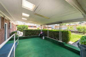 Covered patio featuring integrated lighting and skylights, outdoor carpeting, and a perimeter railing