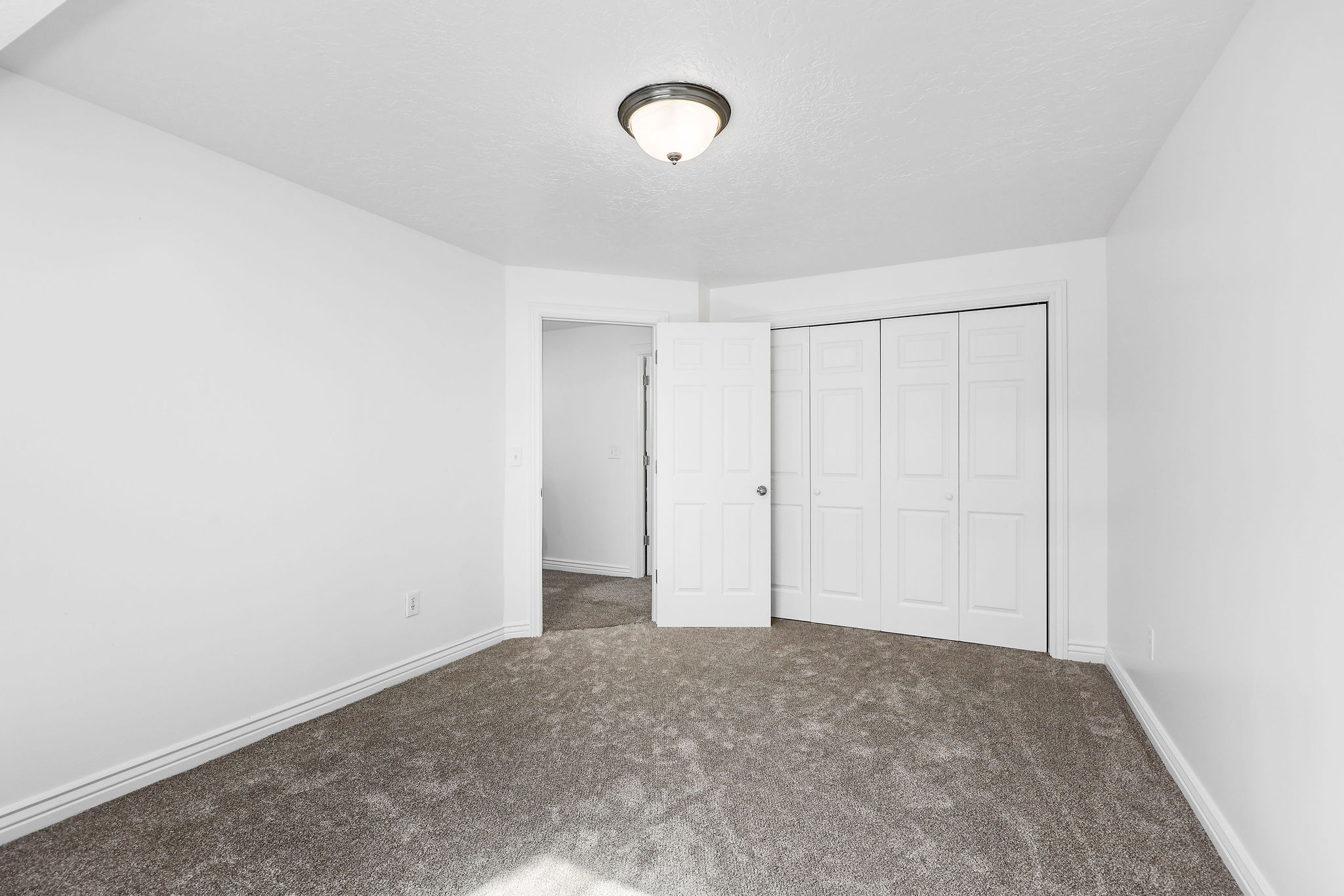 Carpeted interior space featuring white walls and baseboards