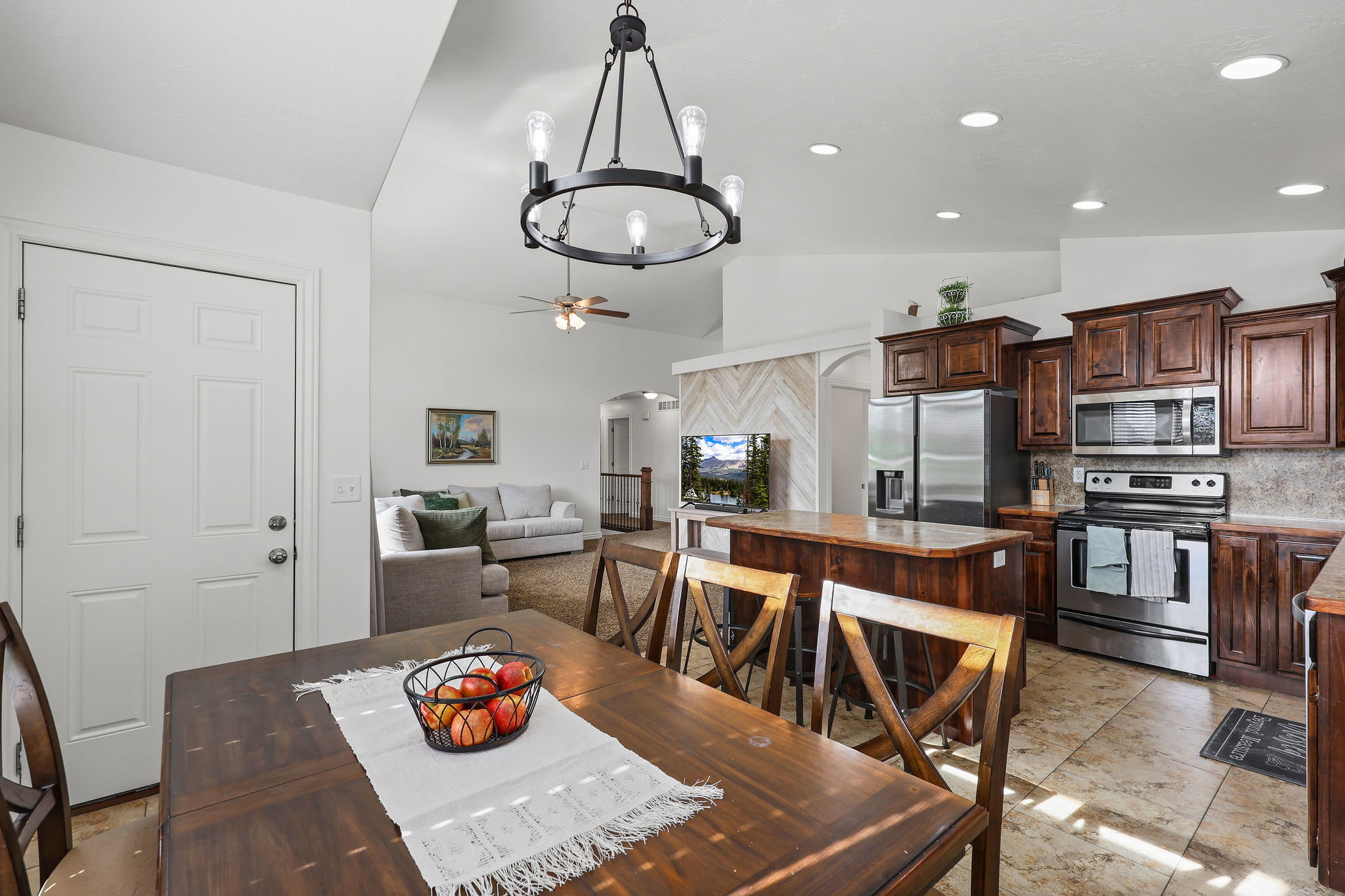 Expansive kitchen featuring wood-finish cabinetry, stainless steel appliances, and a central island with countertop seating