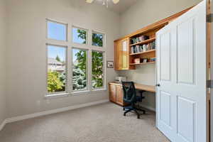 Office with soaring ceilings , custom cabinetry  and built in desk