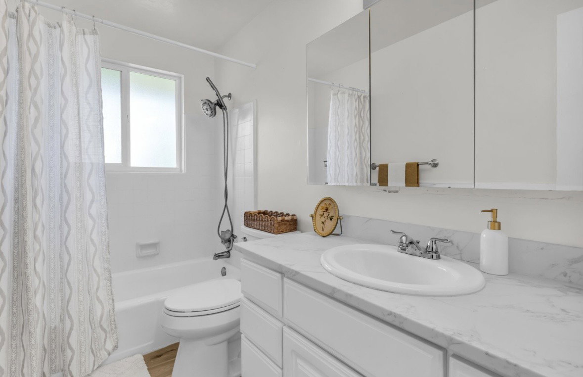 Bathroom featuring a white vanity with an undermount sink, a stone-finish countertop, and a mirrored medicine cabinet