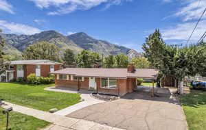 Brick ranch-style home featuring a covered carport, a concrete driveway, and a front walkway