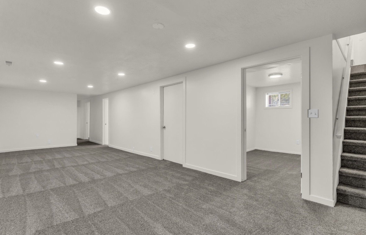 Spacious multi-purpose room featuring patterned carpeting, recessed lighting, and white trim throughout