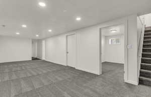 Spacious multi-purpose room featuring patterned carpeting, recessed lighting, and white trim throughout