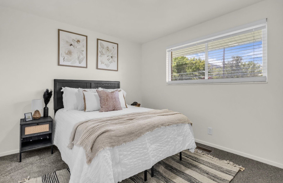 Light-toned walls complement the dark textured headboard