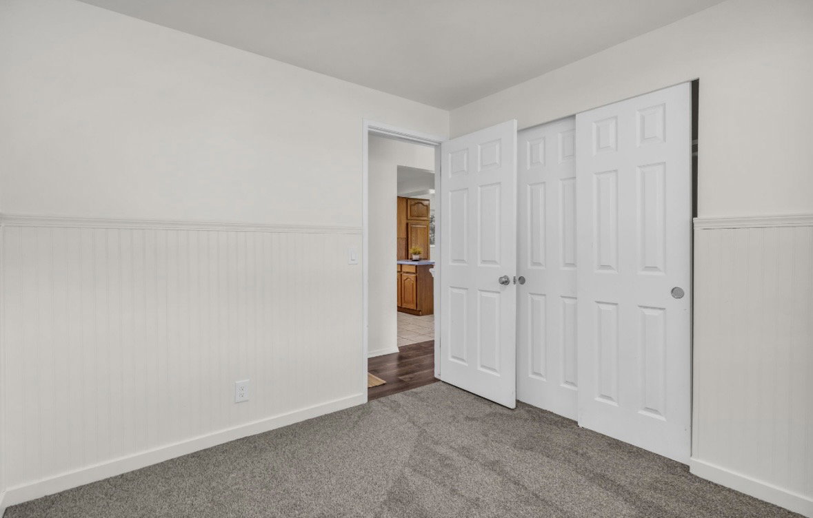 Room featuring neutral wall paint and white beadboard wainscoting
