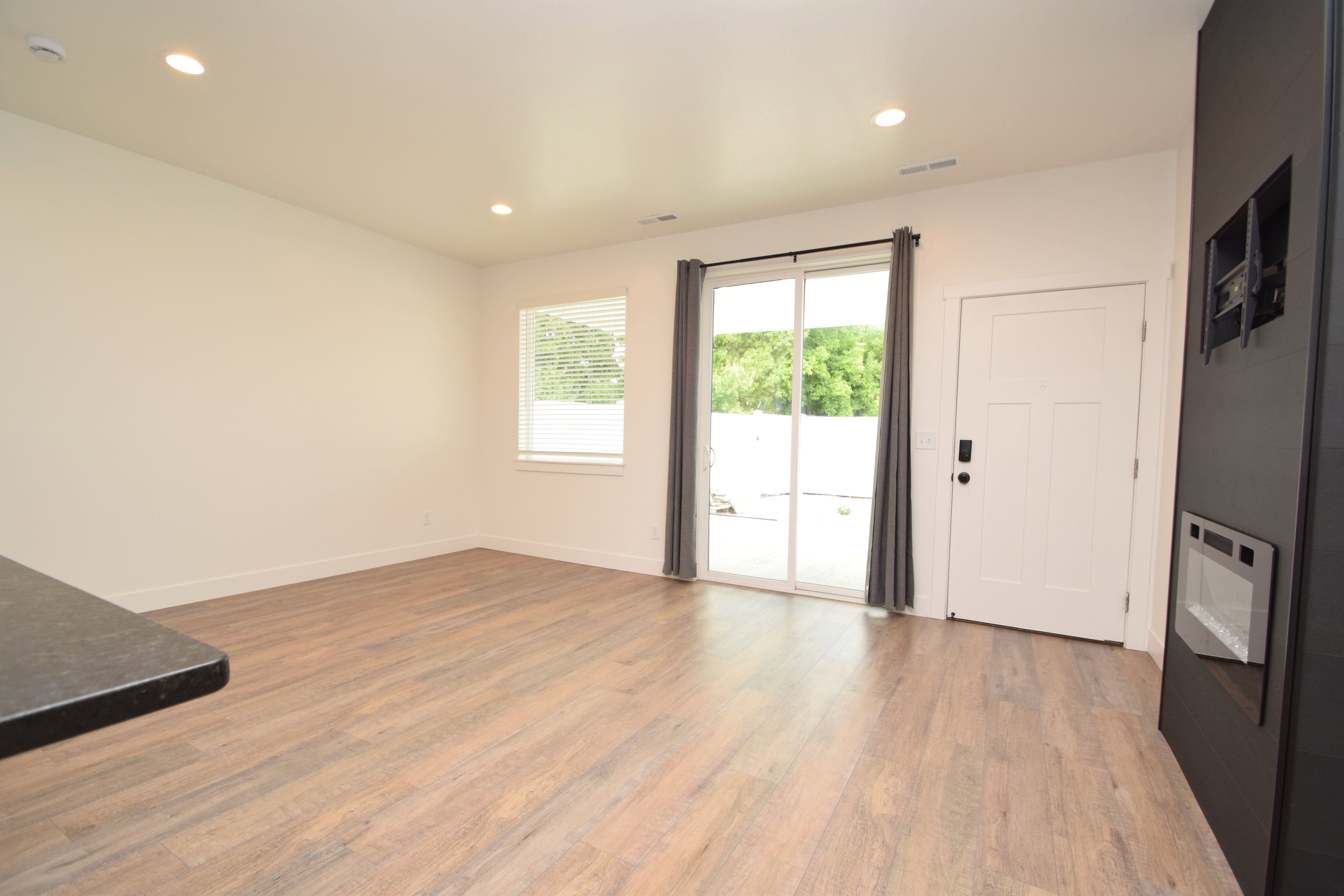 Open-concept living area featuring wood-finish flooring, recessed lighting, and a built-in electric fireplace